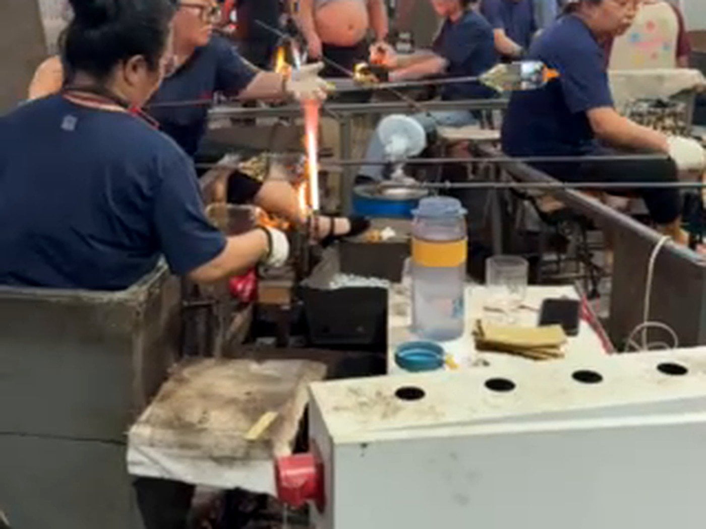 Glassmaker using skilled hands to shape and finish a glass vessel