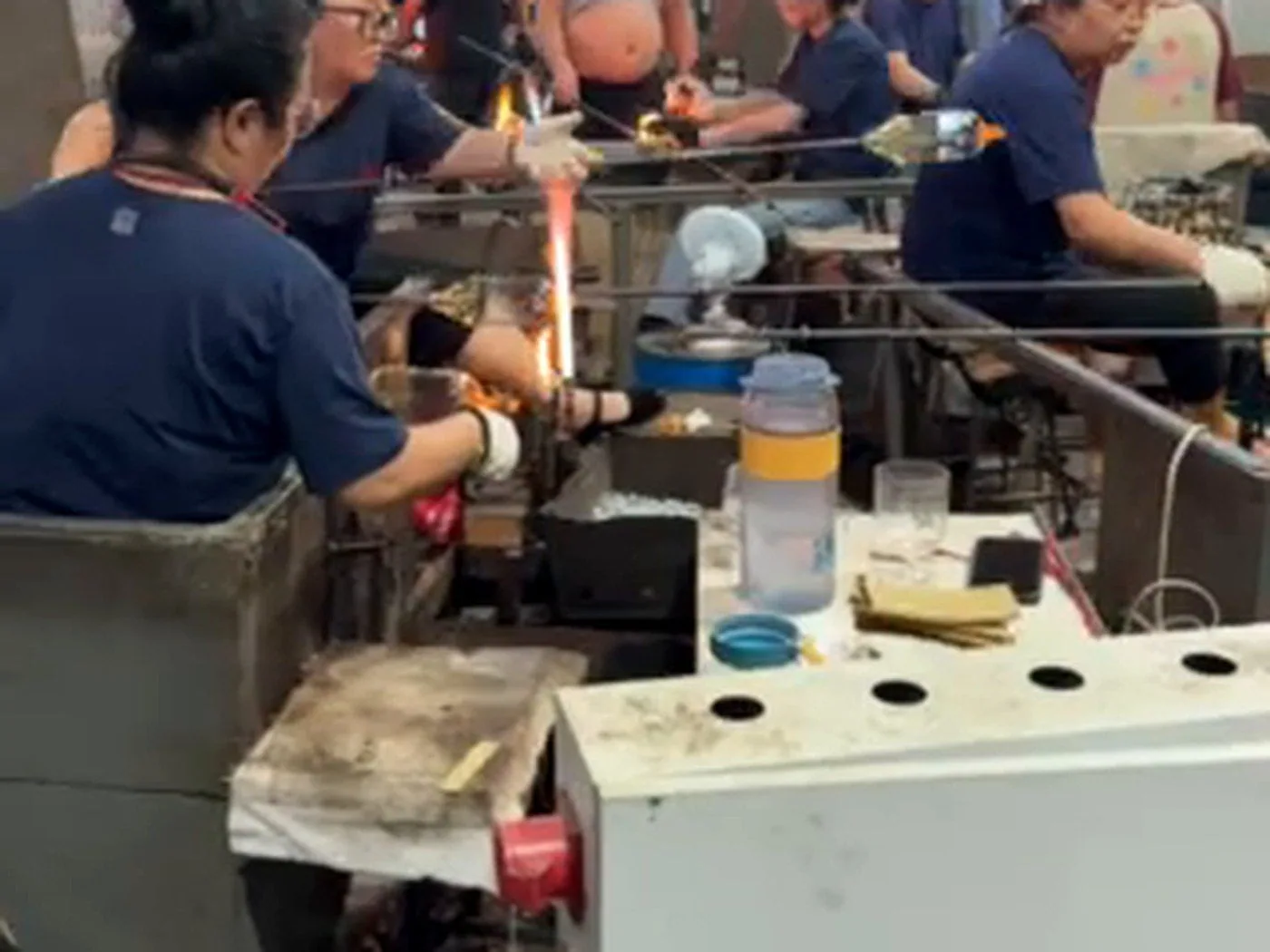 Glassmaker using skilled hands to shape and finish a glass vessel